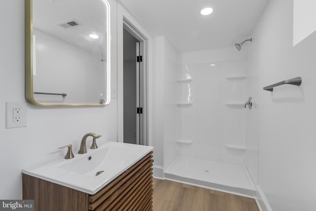 6818 Connecticut Ave, Chevy Chase, MD 20815 - bathroom with vanity, wood finished floors, a shower, and recessed lighting