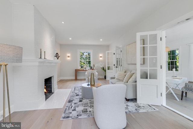 6818 Connecticut Ave, Chevy Chase, MD 20815 - living room with a brick fireplace, wood finished floors, recessed lighting, and french doors
