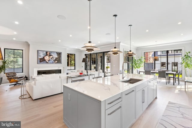 3119 38th St NW, Washington, DC 20016 - kitchen featuring an island with sink, ornamental molding, light wood-style flooring, healthy amount of natural light, and recessed lighting