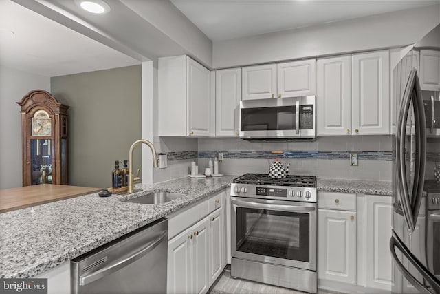 703 Wharton Rd, Mount Laurel, NJ 08054 - kitchen with appliances with stainless steel finishes, white cabinetry, tasteful backsplash, and light stone counters