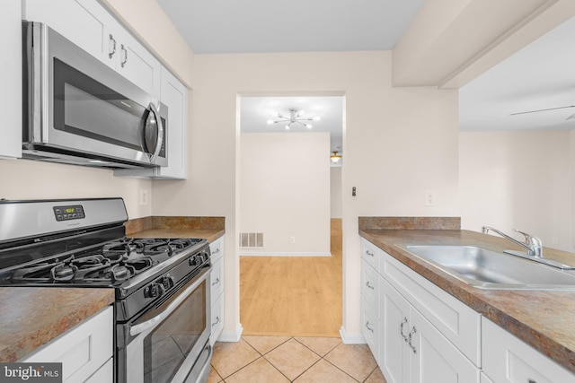 2802B Yarmouth Ln, Mount Laurel, NJ 08054 - kitchen featuring appliances with stainless steel finishes, white cabinets, light tile patterned flooring, and a chandelier