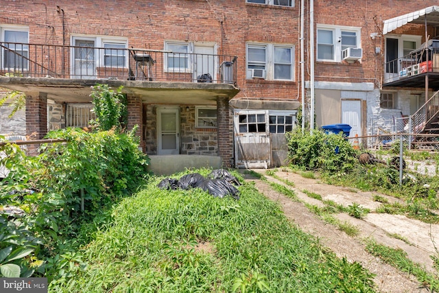 11 Rosedale St, Baltimore, MD 21229 - view of front of home with cooling unit, brick siding, stone siding, and a balcony