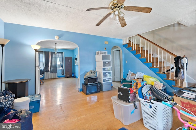 11 Rosedale St, Baltimore, MD 21229 - living area with arched walkways, ceiling fan, wood finished floors, a textured ceiling, and stairs