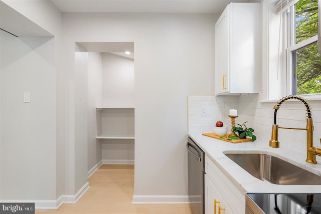 4618 Arabia Ave, Baltimore, MD 21214 - kitchen with stainless steel dishwasher, decorative backsplash, white cabinetry, light stone countertops, and light wood finished floors