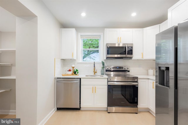 4618 Arabia Ave, Baltimore, MD 21214 - kitchen with appliances with stainless steel finishes, light countertops, white cabinets, backsplash, and light wood finished floors