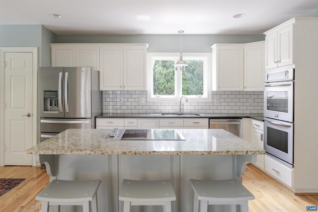 325 Heron Ln, Charlottesville, VA 22903 - kitchen featuring appliances with stainless steel finishes, light wood-style flooring, tasteful backsplash, white cabinets, and recessed lighting
