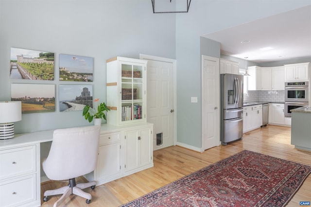 325 Heron Ln, Charlottesville, VA 22903 - kitchen featuring stainless steel appliances, light wood-style floors, white cabinets, and tasteful backsplash