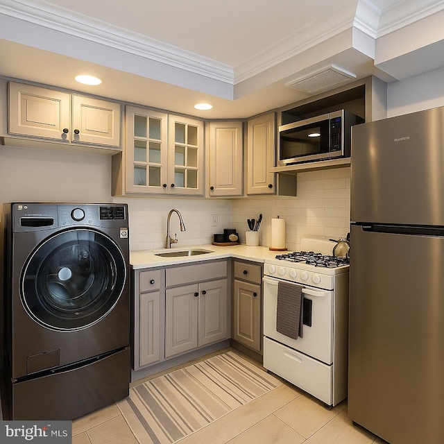 11 2nd St NE Unit 102, Washington, DC 20002 - kitchen featuring stainless steel appliances, washer / clothes dryer, ornamental molding, decorative backsplash, and gray cabinets