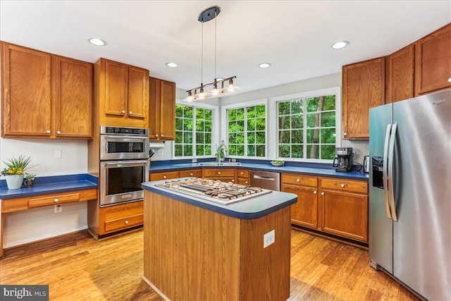 9409 Emory Grove Rd, Gaithersburg, MD 20877 - kitchen with appliances with stainless steel finishes, dark countertops, light wood finished floors, brown cabinetry, and a center island
