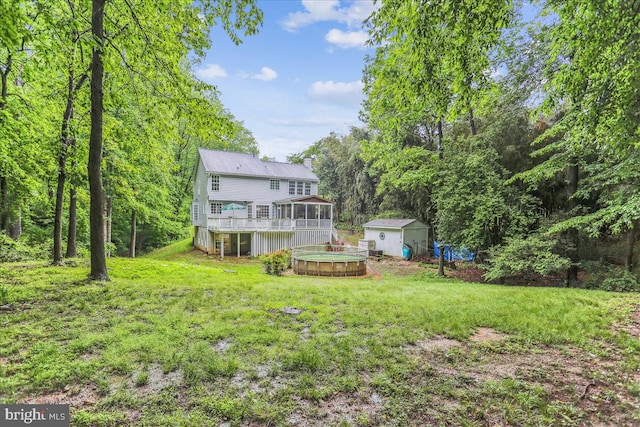 9409 Emory Grove Rd, Gaithersburg, MD 20877 - rear view of property with a storage unit, a wooden deck, a sunroom, a lawn, and a chimney