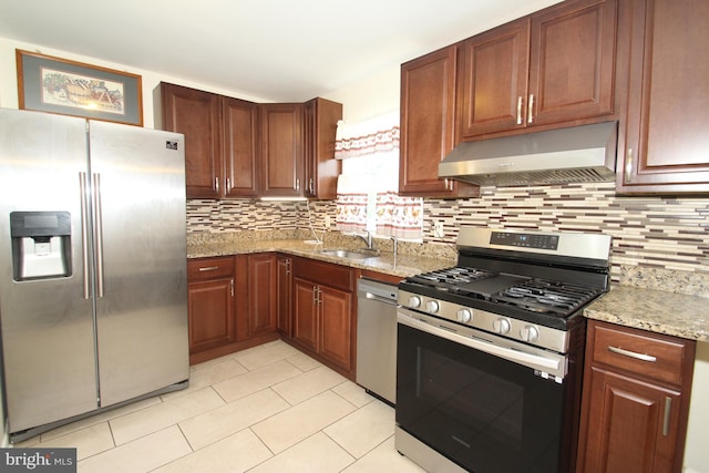 804 N Augustine St, Wilmington, DE 19804 - kitchen featuring appliances with stainless steel finishes, exhaust hood, backsplash, and light stone countertops