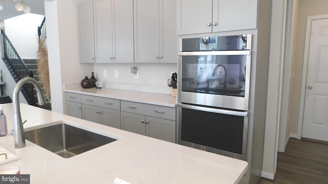 12507 Olivine Ct, Hagerstown, MD 21740 - kitchen with double oven, gray cabinets, light countertops, and dark wood-style floors
