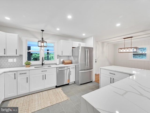 1020 Wyomissing Blvd, Wyomissing, PA 19610 - kitchen with stainless steel appliances, backsplash, white cabinets, pendant lighting, and light stone countertops