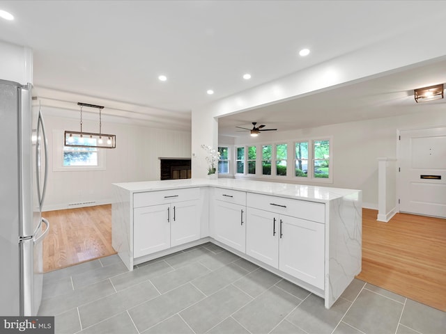 1020 Wyomissing Blvd, Wyomissing, PA 19610 - kitchen featuring freestanding refrigerator, white cabinetry, light stone countertops, a ceiling fan, and recessed lighting