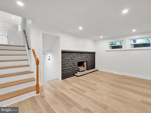 1020 Wyomissing Blvd, Wyomissing, PA 19610 - unfurnished living room featuring light wood-type flooring, stairs, a stone fireplace, and recessed lighting
