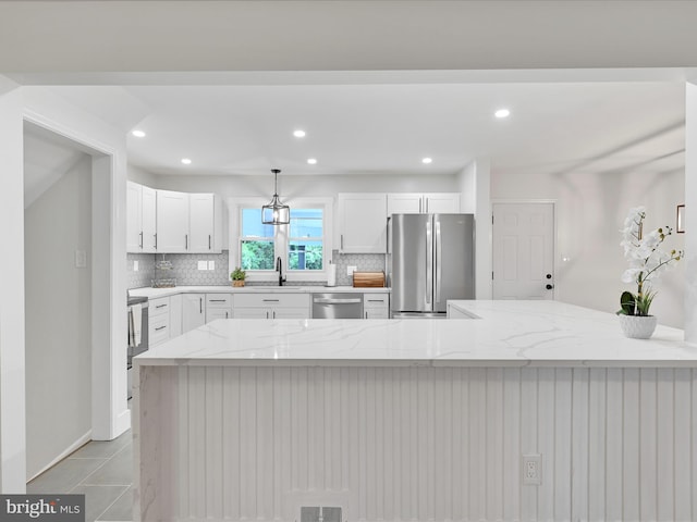 1020 Wyomissing Blvd, Wyomissing, PA 19610 - kitchen featuring stainless steel appliances, decorative backsplash, white cabinets, light stone countertops, and recessed lighting