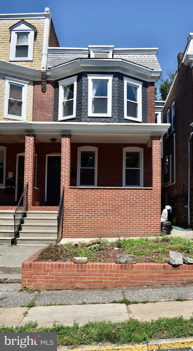 607 N Broom St, Wilmington, DE 19805 - view of front of house featuring mansard roof, brick siding, a porch, and a high end roof