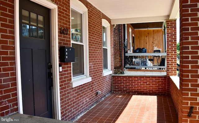 607 N Broom St, Wilmington, DE 19805 - property entrance featuring covered porch and brick siding
