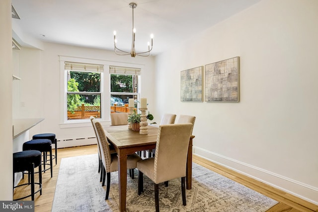 3105 17th St NW, Washington, DC 20010 - dining area featuring a chandelier, light wood-style floors, and a baseboard heating unit