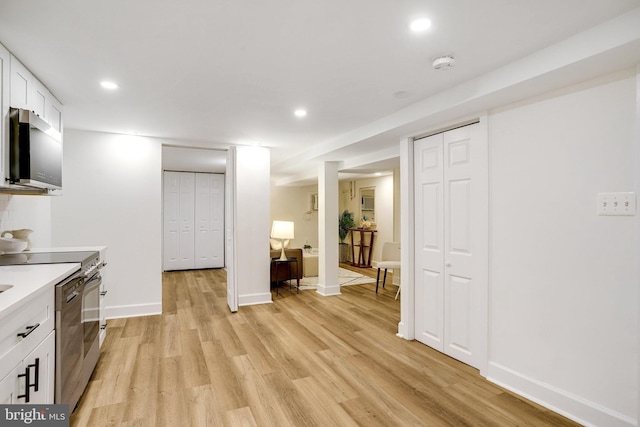 3105 17th St NW, Washington, DC 20010 - kitchen with stainless steel microwave, light wood-style floors, recessed lighting, white cabinets, and light countertops