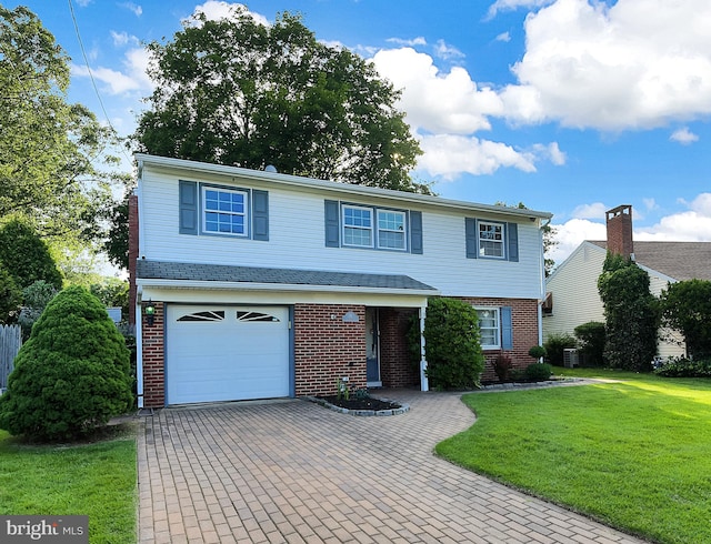 15 Constance Dr, Hamilton, NJ 08620 - view of front of house with brick siding, a front lawn, an attached garage, and decorative driveway