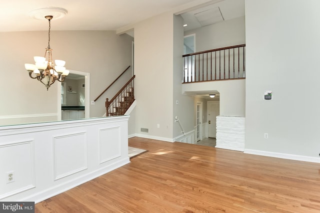 15 Constance Dr, Hamilton, NJ 08620 - unfurnished room with a chandelier, wood finished floors, stairway, and high vaulted ceiling