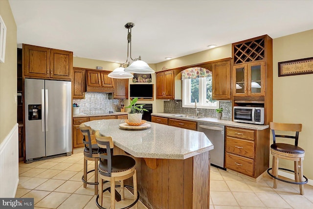 615 Beinhower Rd, Etters, PA 17319 - kitchen featuring appliances with stainless steel finishes, brown cabinetry, light tile patterned floors, and a kitchen island