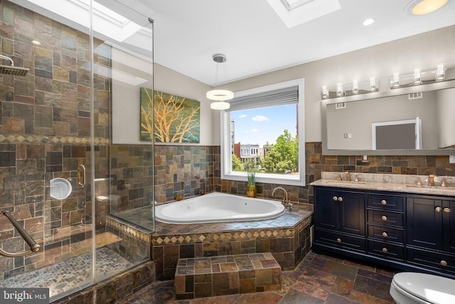 1125 K St NE, Washington, DC 20002 - bathroom with a skylight, stone tile floors, a garden tub, double vanity, and a shower stall