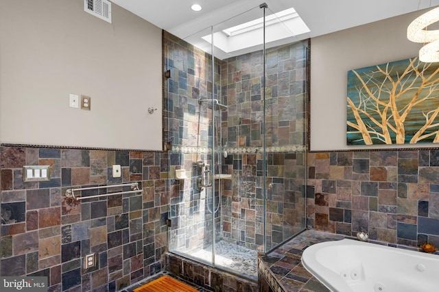 1125 K St NE, Washington, DC 20002 - full bathroom featuring a skylight, tile walls, a jetted tub, a shower stall, and recessed lighting