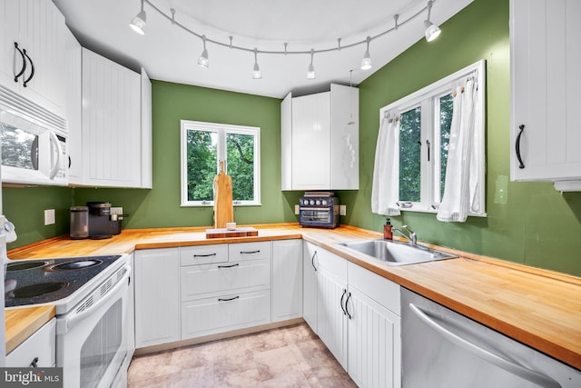 148 Reservoir Rd, Hopewell, NJ 08525 - kitchen with wood counters, white appliances, white cabinets, and rail lighting
