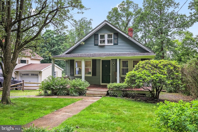 148 Reservoir Rd, Hopewell, NJ 08525 - bungalow-style house featuring covered porch, a chimney, a front yard, a detached garage, and an outbuilding
