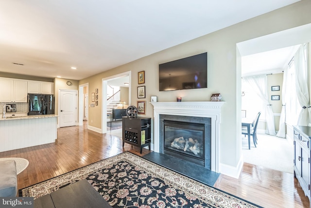 231 Caleb Dr, West Chester, PA 19382 - living area with light wood-style floors, stairway, a glass covered fireplace, recessed lighting, and plenty of natural light