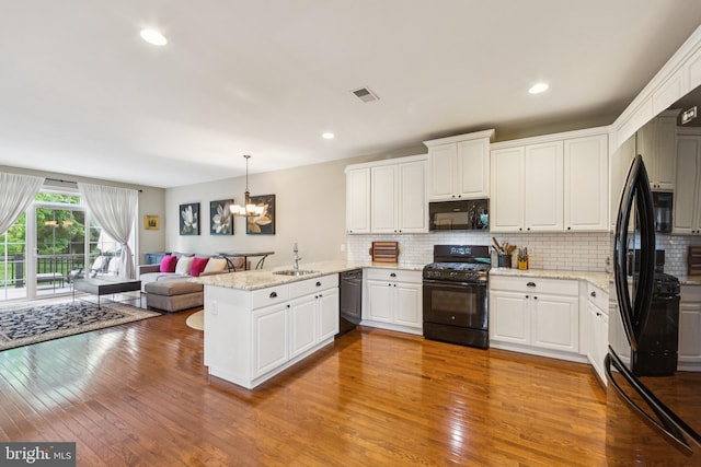 231 Caleb Dr, West Chester, PA 19382 - kitchen with black appliances, a peninsula, open floor plan, hardwood / wood-style floors, and recessed lighting