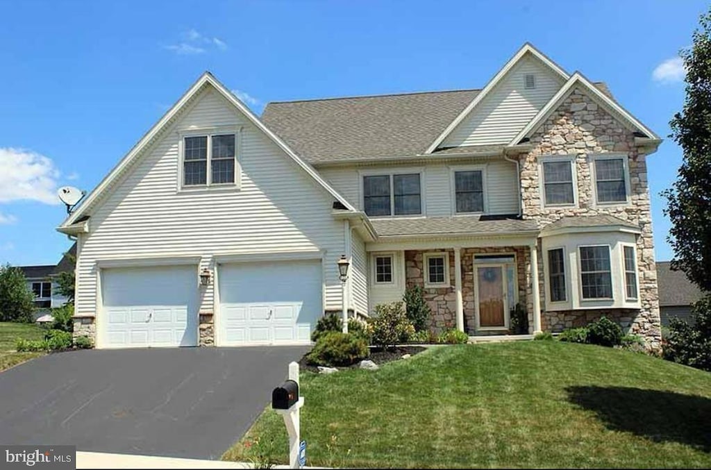 317 Cobblers Ct, Lititz, PA 17543 - view of front of property with stone siding, driveway, a front yard, and an attached garage
