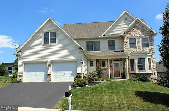 317 Cobblers Ct, Lititz, PA 17543 - view of front of property with stone siding, driveway, a front yard, and an attached garage