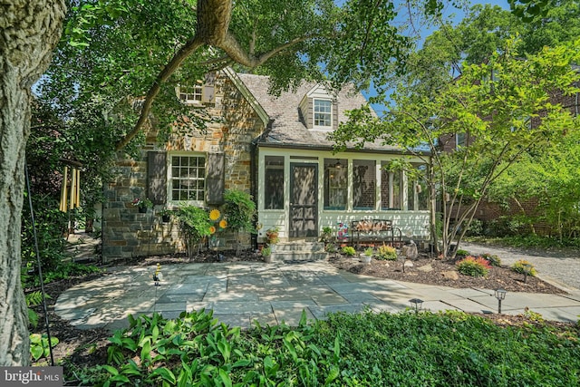 2833 Northampton St NW, Washington, DC 20015 - view of front of house featuring stone siding, a sunroom, and a patio