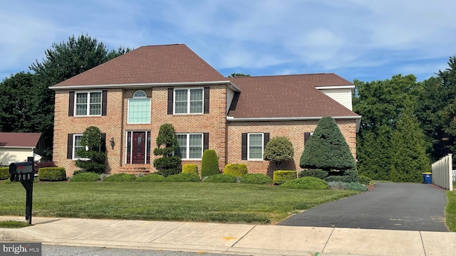 908 W S St, Smyrna, DE 19977 - colonial home featuring brick siding, a front yard, and a shingled roof