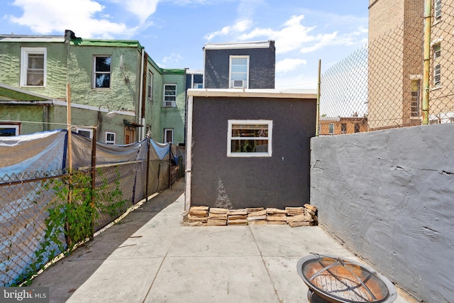 3567 Joyce St, Philadelphia, PA 19134 - rear view of property with stucco siding, a patio, a fenced backyard, and an outdoor fire pit