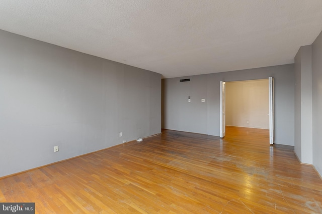 1101 Saint Paul St Unit 603, Baltimore, MD 21202 - spare room featuring light wood-style floors and a textured ceiling