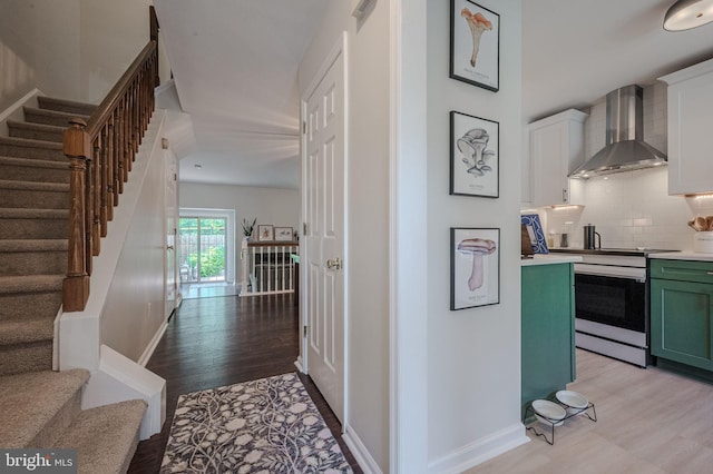 642 Lamplighter Way, Hockessin, DE 19707 - kitchen featuring wall chimney range hood, green cabinets, electric range, tasteful backsplash, and light countertops