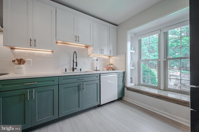 642 Lamplighter Way, Hockessin, DE 19707 - kitchen with white dishwasher, light wood-style flooring, light countertops, decorative backsplash, and white cabinetry