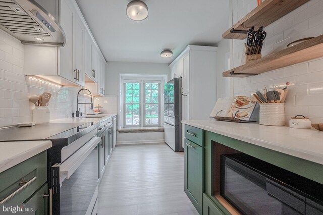 642 Lamplighter Way, Hockessin, DE 19707 - kitchen with green cabinets, extractor fan, white range with electric stovetop, black microwave, and tasteful backsplash