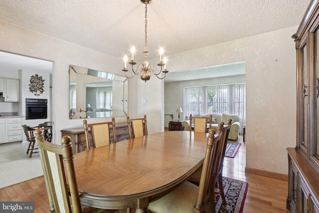 21 Hemmings Way, Lawnside, NJ 08045 - dining area with a textured ceiling, light wood-style flooring, and a chandelier