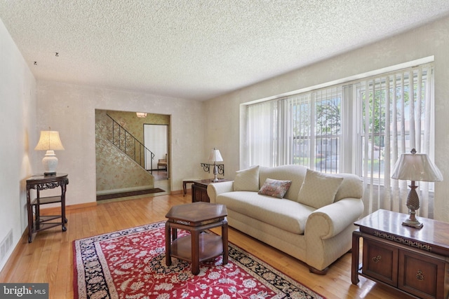 21 Hemmings Way, Lawnside, NJ 08045 - living room with a textured ceiling, stairway, and light wood-style floors
