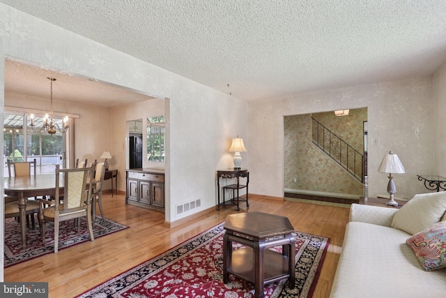 21 Hemmings Way, Lawnside, NJ 08045 - living area featuring light wood-style floors, a chandelier, a textured ceiling, and stairs