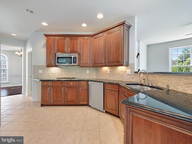 7730 Terraview Ct, Hanover, MD 21076 - kitchen featuring stainless steel appliances, dark stone countertops, tasteful backsplash, brown cabinets, and light tile patterned flooring