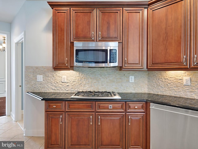 7730 Terraview Ct, Hanover, MD 21076 - kitchen with stainless steel appliances, light tile patterned flooring, backsplash, and brown cabinetry