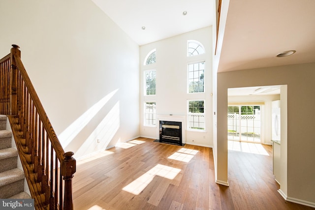 202 Park Knl, Princeton, NJ 08540 - unfurnished living room featuring a towering ceiling, wood finished floors, stairway, and a fireplace with flush hearth