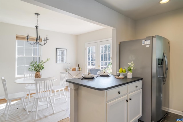 324 NW 8th St, Charlottesville, VA 22903 - kitchen featuring stainless steel fridge, a chandelier, white cabinets, hanging light fixtures, and dark countertops