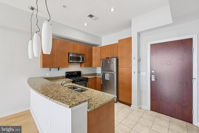 1209 N Charles St Unit 409, Baltimore, MD 21201 - kitchen featuring appliances with stainless steel finishes, brown cabinets, light stone countertops, a peninsula, and recessed lighting